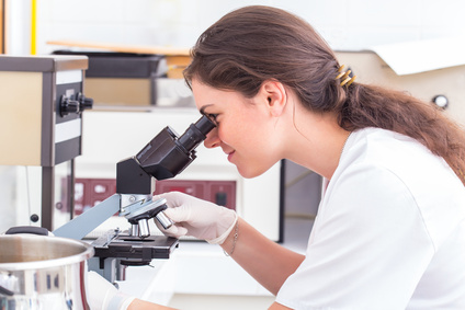 closeup for a female medical student making a researsch using a microscope