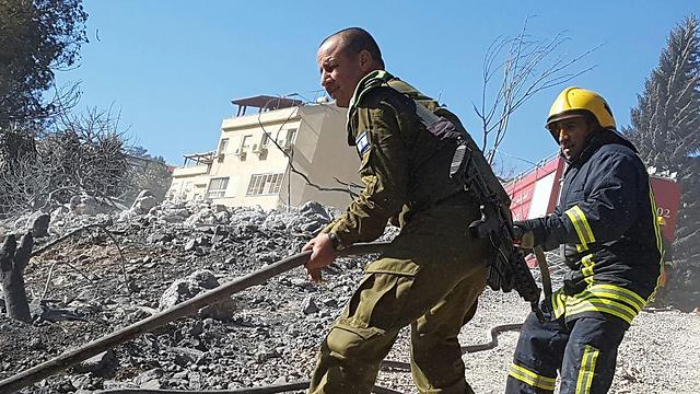 Un pompiere israeliano e uno palestinese collaborano per spegnere le fiamme