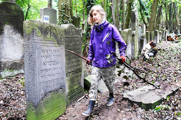 Una giovane volontaria pulisce il cimitero ebraico di Varsavia