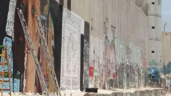 Il murales fatto sul muro da Jorit e l'altro street artist 