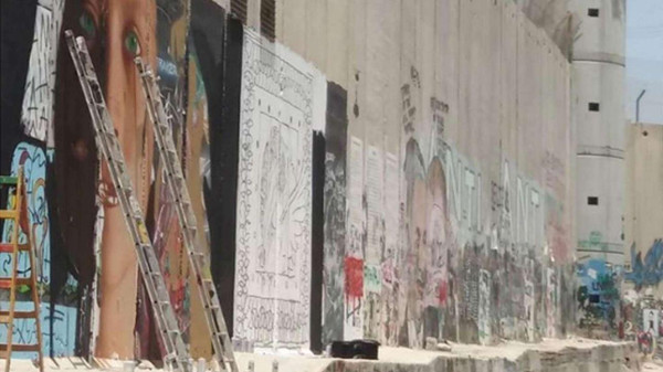 Il murales fatto sul muro da Jorit e l'altro street artist