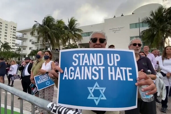 Un uomo con cartello con magen david alla manifestazione a Miami contro antisemitismo