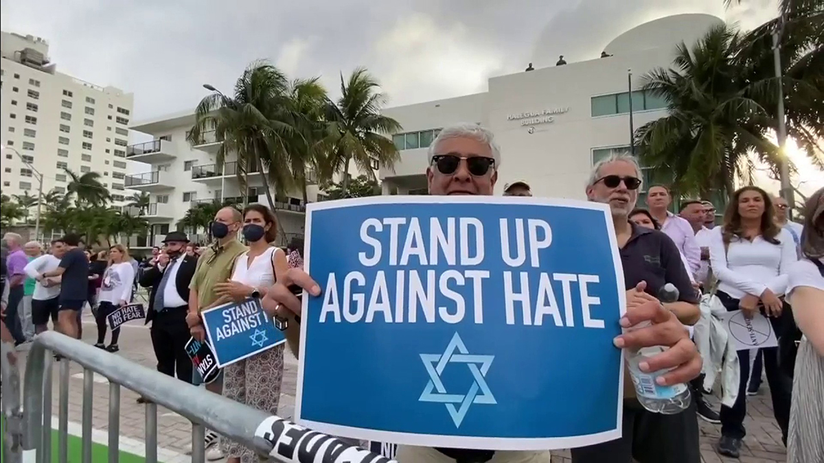 Un uomo con cartello con magen david alla manifestazione a Miami contro antisemitismo