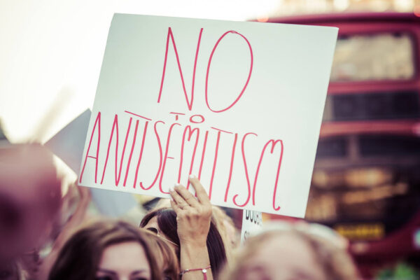Una mnaifestante con un cartello contro l'antisemitismo